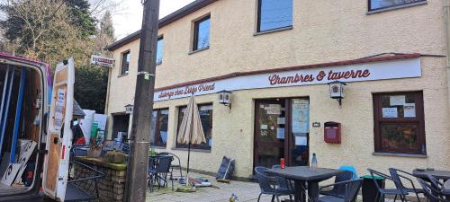 a store with tables and chairs in front of a building at Dikke Vriend , herberg & taverne in Chiny