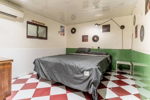 1 dormitorio con 1 cama y suelo a cuadros en Stay&Chill H.4 - Vintage Flat near Ben Thanh, en Ho Chi Minh