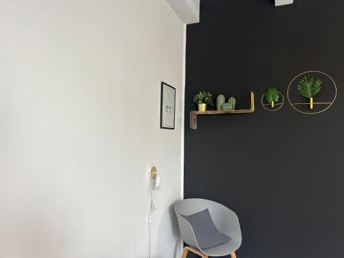 una silla blanca en una habitación con una pared negra en 87029house, en Scalea