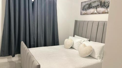 a bedroom with a bed with black curtains and white pillows at The Blyde Crystal Lagoon Luxury Stays in Pretoria