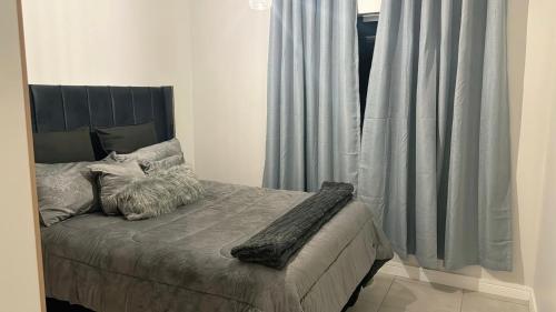 a bedroom with a bed and a window with curtains at The Blyde Crystal Lagoon Luxury Stays in Pretoria