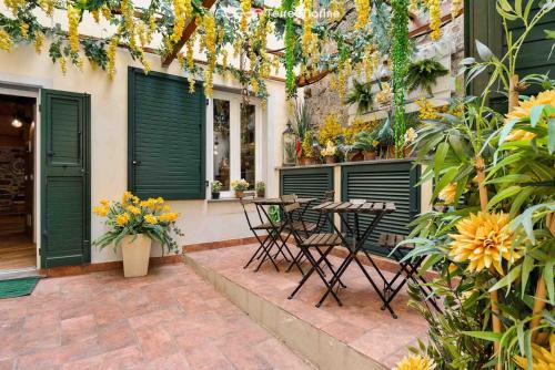 a patio with a table and chairs and flowers at Mia Home, Terre Marine in Riomaggiore