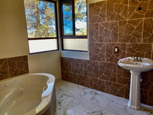 een badkamer met een bad en een wastafel bij Finca el Péndulo in Tepatitlán de Morelos