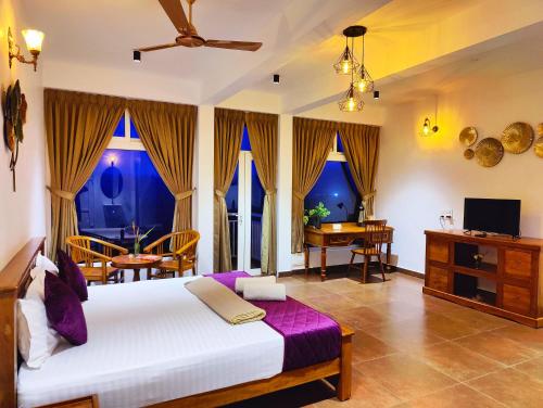 a bedroom with a bed and a table and chairs at The Highlander in Vagamon