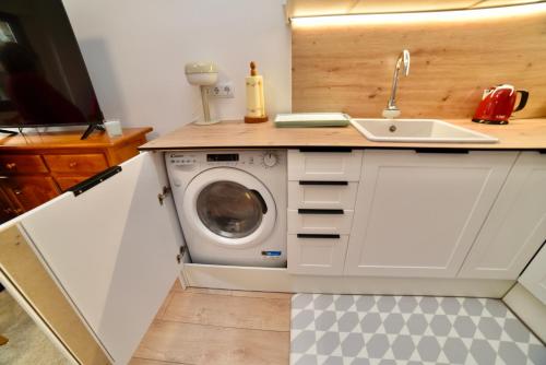 a kitchen with a washing machine and a sink at El balcón de la inspiración en plena natura HUT-8434 Encamp in Encamp