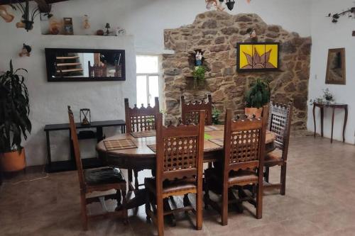 a dining room with a wooden table and chairs at Finca La Sara in Ubaté