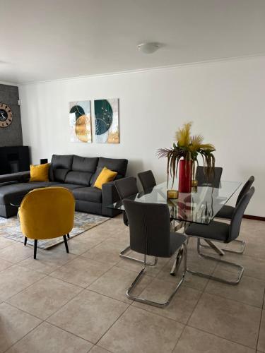 a living room with a glass table and chairs at Populo Beach Villa, Walk to Beach, Air Conditioning and Heating, near Ponta Delgada in Livramento