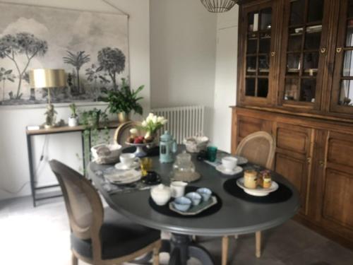 - une table à manger avec des chaises et une table avec de la nourriture dans l'établissement Fleur de l Elorn, à Guipavas