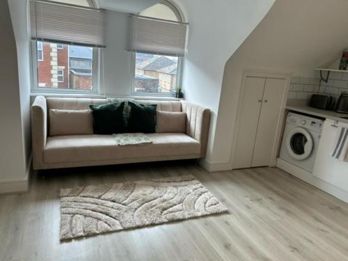 a living room with a couch and a washing machine at churchward house flat 4 in Chertsey