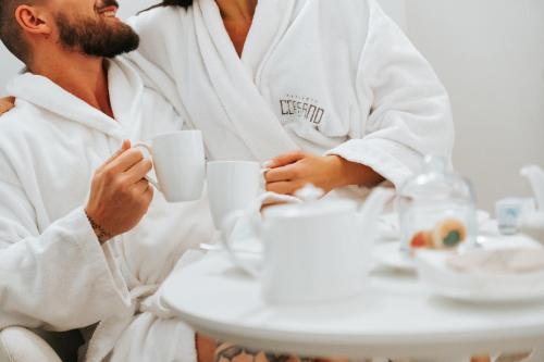 a man and woman in white bath robes drinking coffee at Masseria Corsano in Nardò