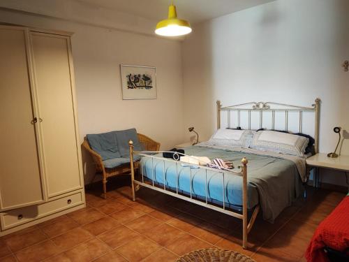 a bedroom with a bed and a chair at Casa Vacanze "Dimora Quercia" - Appartamento "Oliva" in Montefalco