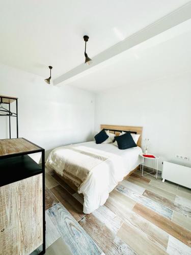 a white bedroom with a large bed and a desk at Ventana a la Ría in Ferrol