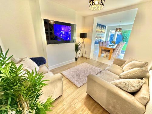 a living room with a couch and a flat screen tv at Large Four Bedroom - With Hot Tub and Parking - Sleeps 8 in Poole