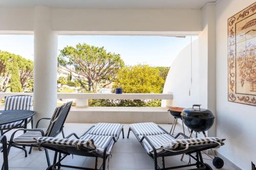 a balcony with chairs and a table and a grill at Cozy 2 BDR W/Balcony in Vale do Lobo by LovelyStay in Vale do Lobo