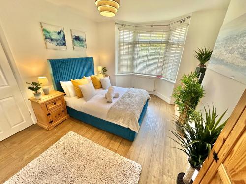 Un dormitorio con una cama azul y una ventana en Large Four Bedroom - With Hot Tub and Parking - Sleeps 8 en Poole