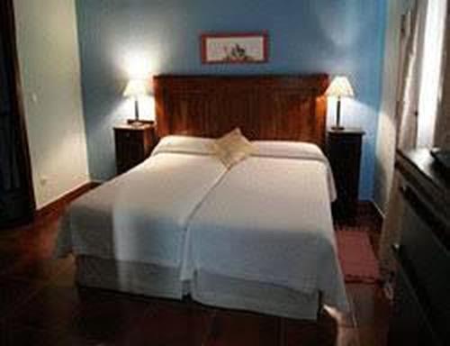 1 dormitorio con 1 cama blanca y paredes azules en Cincosombreros, en Gallegos de San Vicente