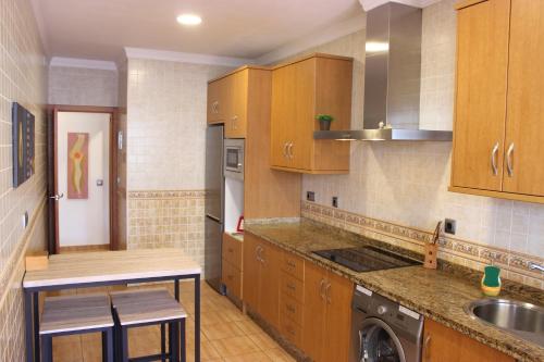 - une cuisine avec des placards en bois et un évier dans l'établissement Gran Apartamento Andévalo, à El Cerro de Andévalo