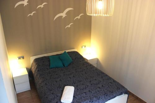 - une chambre avec un lit avec des oiseaux sur le mur dans l'établissement Gran Apartamento Andévalo, à El Cerro de Andévalo