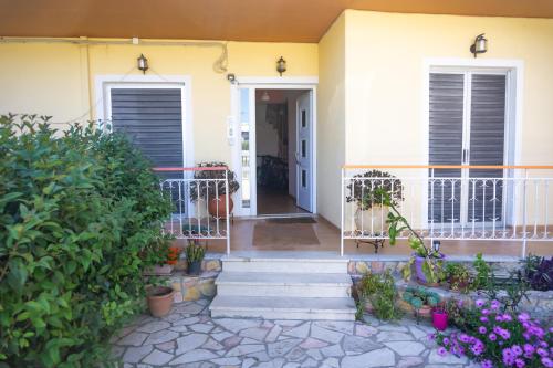 a front porch of a house with flowers at Mema's Tranquil Studio in Patra - Free Parking in Patra