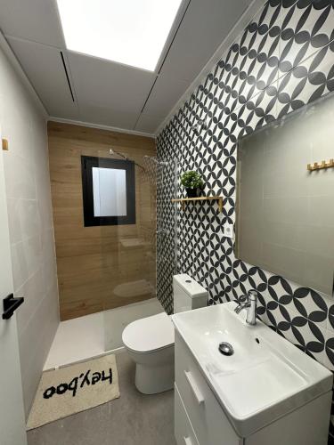 a bathroom with a sink and a toilet and a television at Indalo Mar Menor - Cozy modern stay in Old Town near the beach in Los Alcázares
