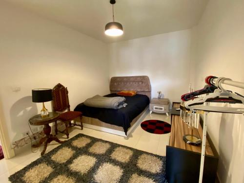 Un dormitorio con una cama, una silla y una mesa. en Madinaty Hotel, en Madinaty