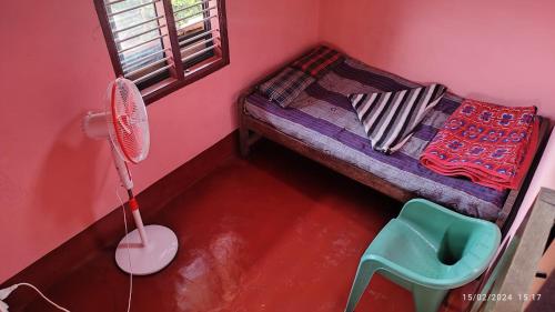 a small pink room with a bed and a chair at Kyathanamakki Base Camp Stay in Kalasa