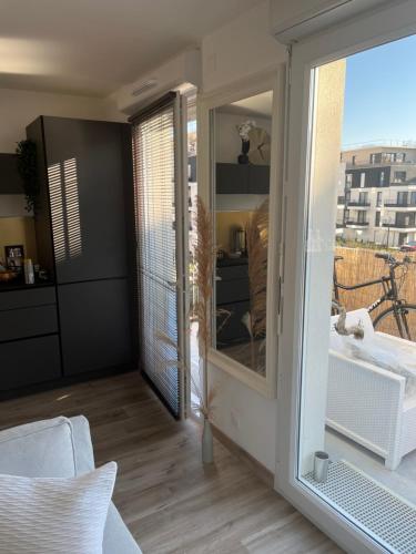 een kamer met een glazen schuifdeur naar een balkon bij Les terrasses de la Marne in Vaires-sur-Marne