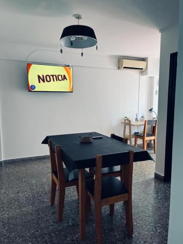 Dpto centrico في لا بلاتا: طاولة سوداء مع كراسي وإشارة على الحائط