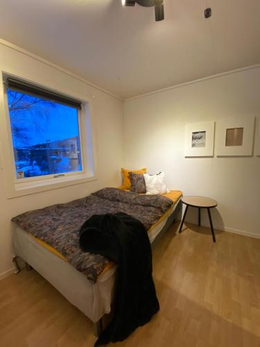 1 dormitorio con cama, ventana y mesa en Leilighet i enebolig, en Bergen