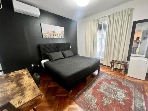 - une chambre avec un lit doté d'une ottomane noire dans l'établissement Hotel Boutique Tremo Bellavista Suite, à Santiago