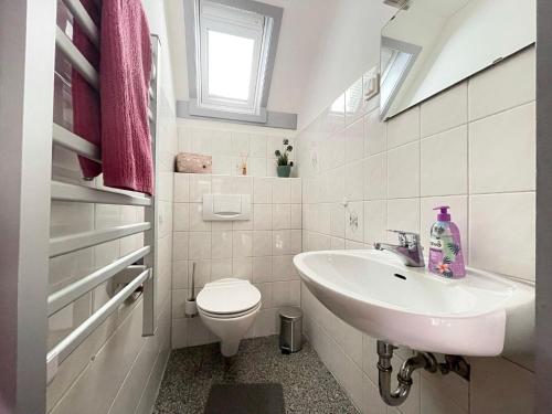 een witte badkamer met een wastafel en een toilet bij Ferienhaus-Heike-Dein-Urlaub-mit-Panoramablick in Kirchheim