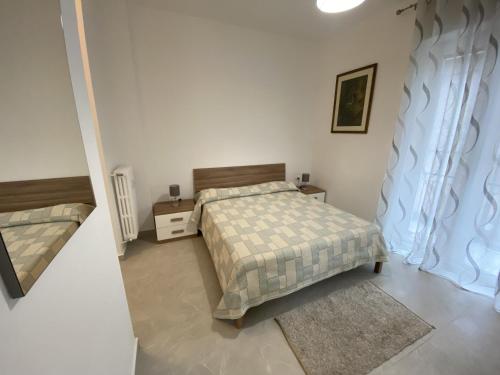 una piccola camera con letto e comodino di La Perla Bianca Regio Parco a Torino