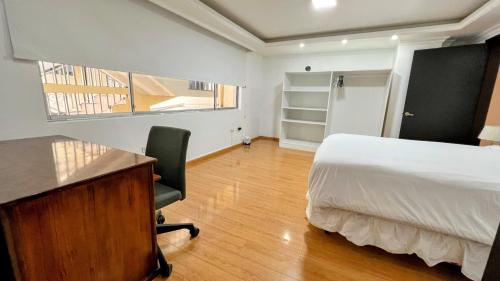 a bedroom with a desk and a bed and a desk at Edificio Tofino in Quito