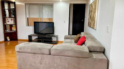 a living room with a couch and a television at Edificio Tofino in Quito