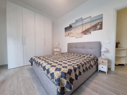 een slaapkamer met een bed met een geruite deken bij Onda Azzurra in Imperia