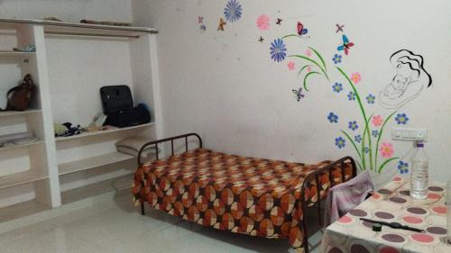 sypialnia z łóżkiem z kwiatami i motylami na ścianie w obiekcie Divyashray w mieście Hajdarabad