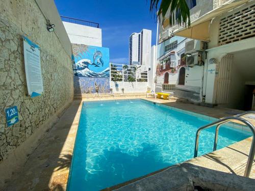 a large blue swimming pool next to a building at Hotel Toledo FL in Cartagena de Indias