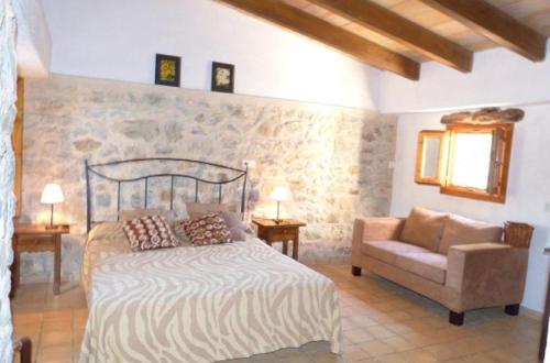a bedroom with a bed and a chair at Casa Villa Las Encinas in Pollença