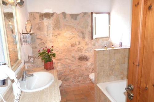 a bathroom with a sink and a toilet and a tub at Casa Villa Las Encinas in Pollença