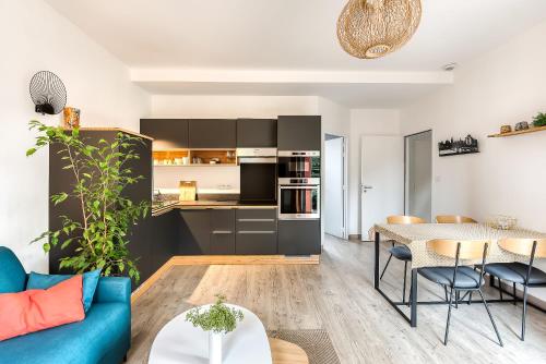 un salon avec un canapé bleu et une table dans l'établissement Gîte T2 A l'orée d'Angers, à Avrillé