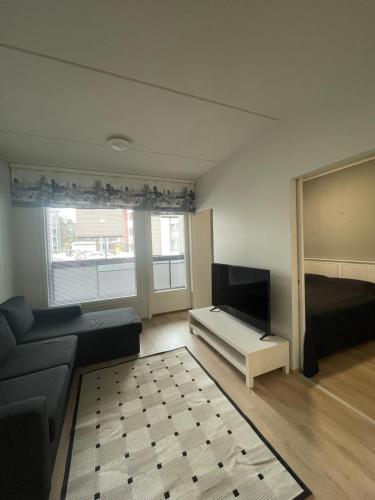 uma sala de estar com um sofá, uma cama e uma televisão em Kempele city center 2 em Kempele