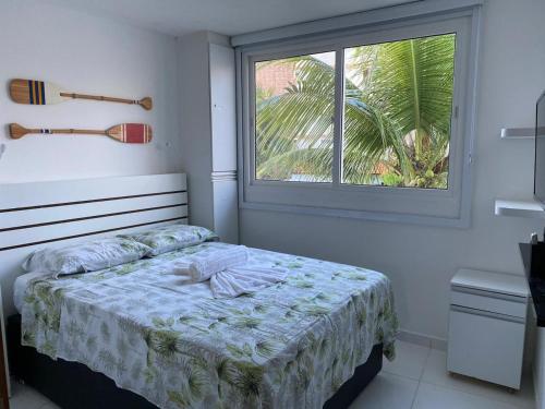 a small bedroom with a bed and a window at Mandakaru Residence Flat 10 in Porto De Galinhas