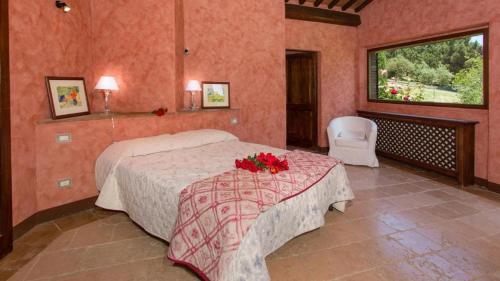Un dormitorio con una cama y una mesa con flores. en PoloTuristicoUmbria Casale Roteto con Piscina en Città di Castello