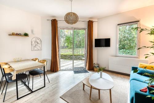 - un salon avec une table et un canapé bleu dans l'établissement Gîte T2 A l'orée d'Angers, à Avrillé