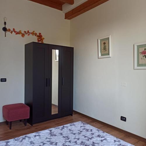 1 dormitorio con armario negro y silla roja en La casetta di Elly, en Puegnago sul Garda
