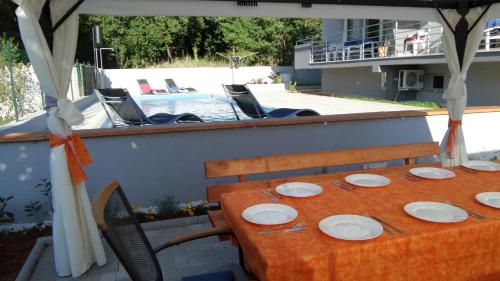 a table and chairs on a balcony with a pool at House Barbara in Banjole
