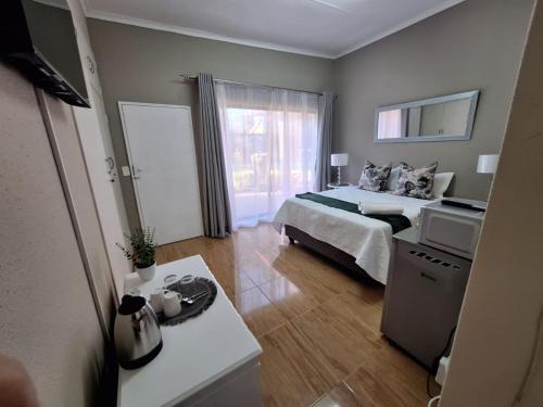 a bedroom with a bed and a table in it at Zhantique Guest House Unit 5 in Boksburg