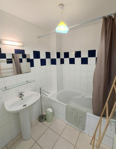 une salle de bain avec une baignoire et un lavabo et une baignoire dans l'établissement soleil catalan terrasse panoramique ok chéques vacances animaux 4pers wifi 65m2 jardin parking 2ch 2km mer, à Latour-Bas-Elne