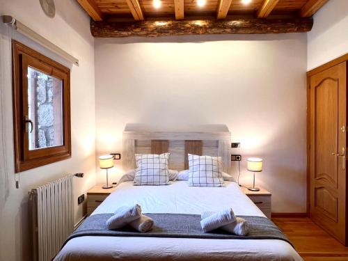 a bedroom with a large bed with two pillows at Can Florido - L'Amfitriona in Sort