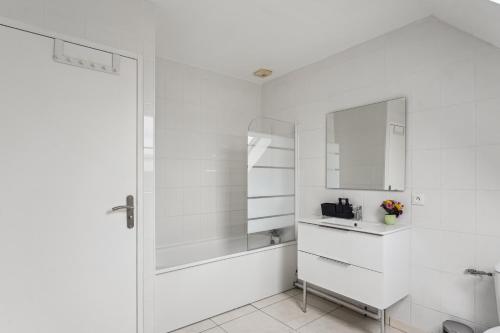 uma casa de banho branca com um lavatório e um espelho em Chic friendly and spacious house em Meaux